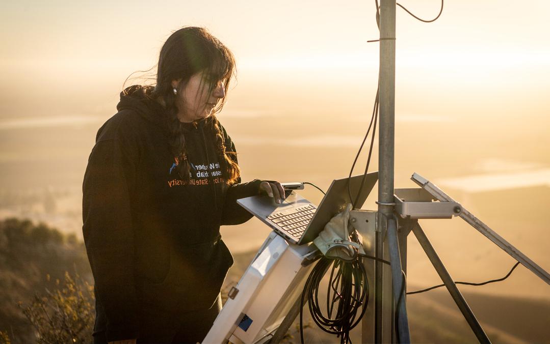 A student working on setting up equipment high in the mountains.